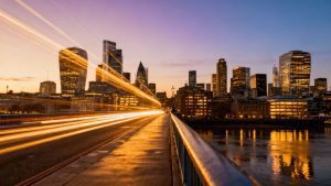 London and New York skylines at dawn with financial market hints.